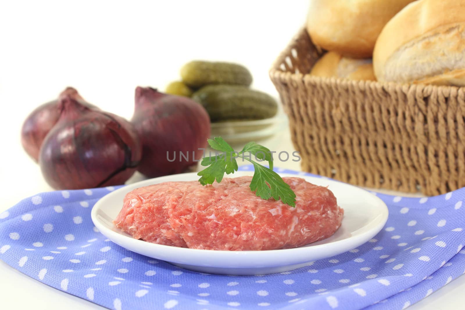 raw minced meat and parsley on a white plate