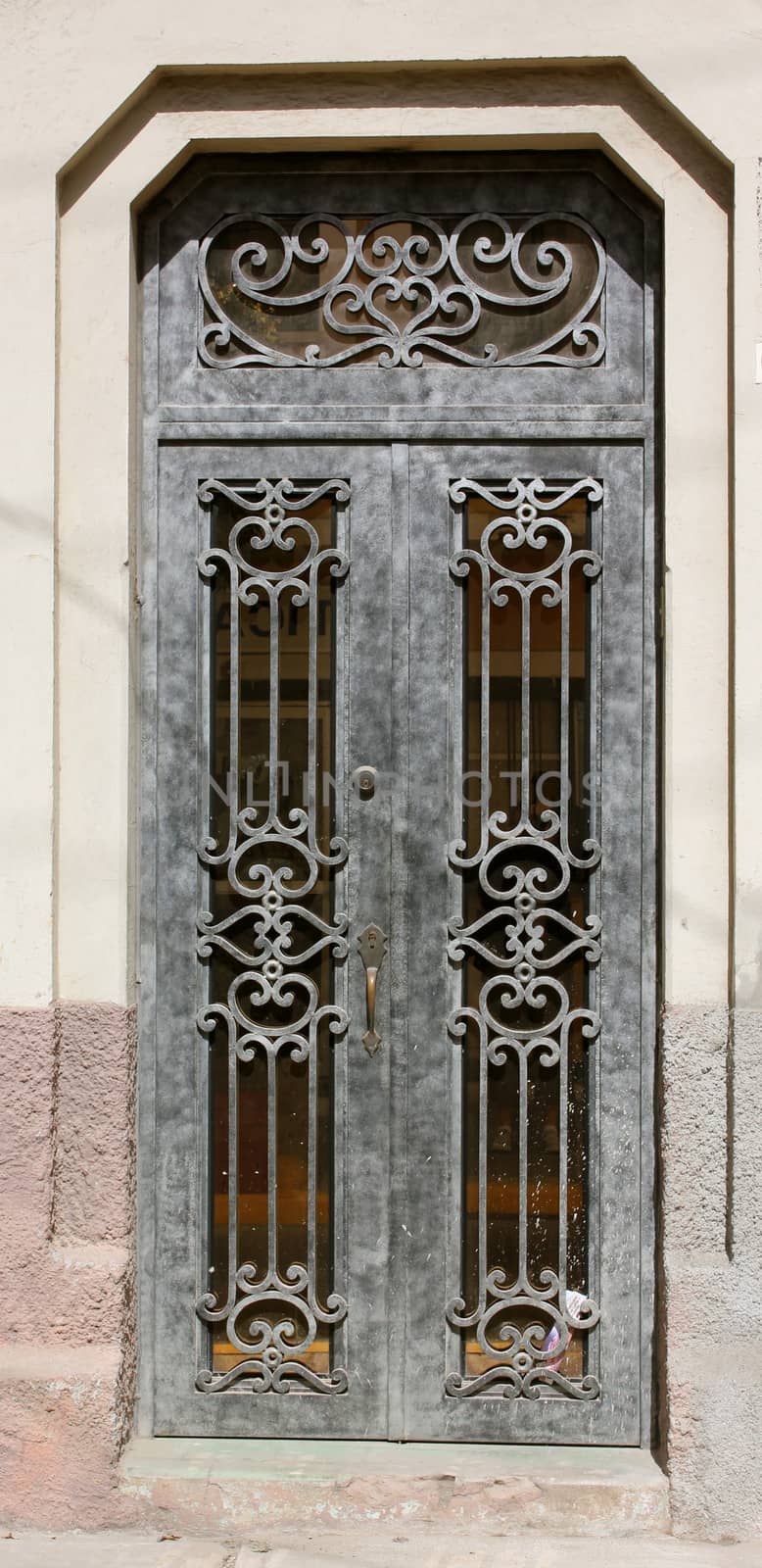 A decorative and aged wrought iron entry door.