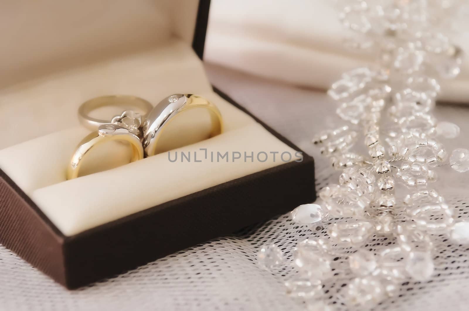 Gold wedding rings with engagement ring inside box 