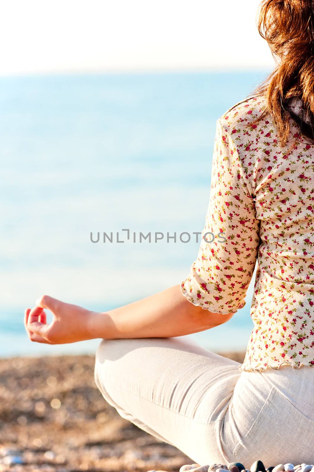 girl in lotus pose on the beach