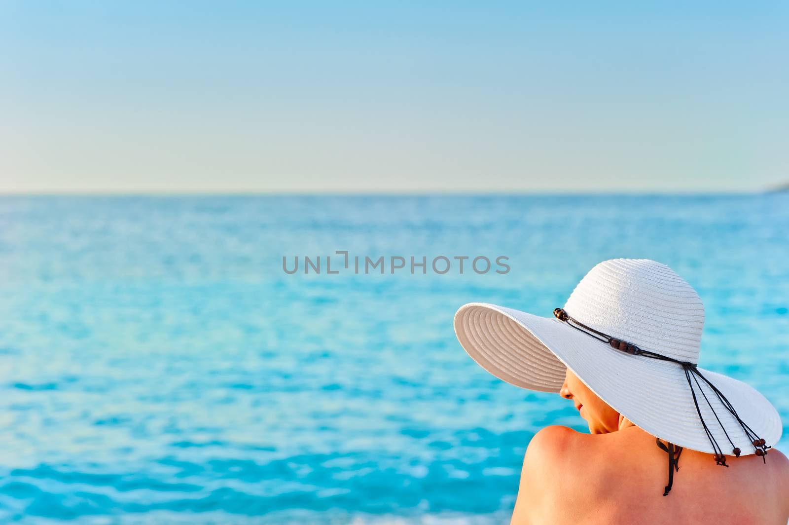 girl in white hat on the beach sunbathing