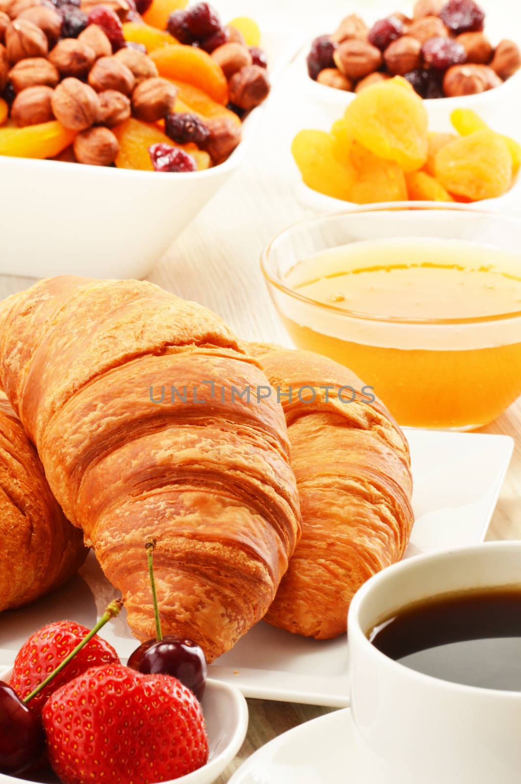 Breakfast with croissants, cup of coffee and fruits