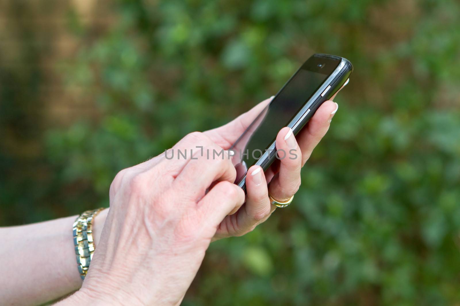 Businesswoman's hands texting on a smart phone or cell phone.