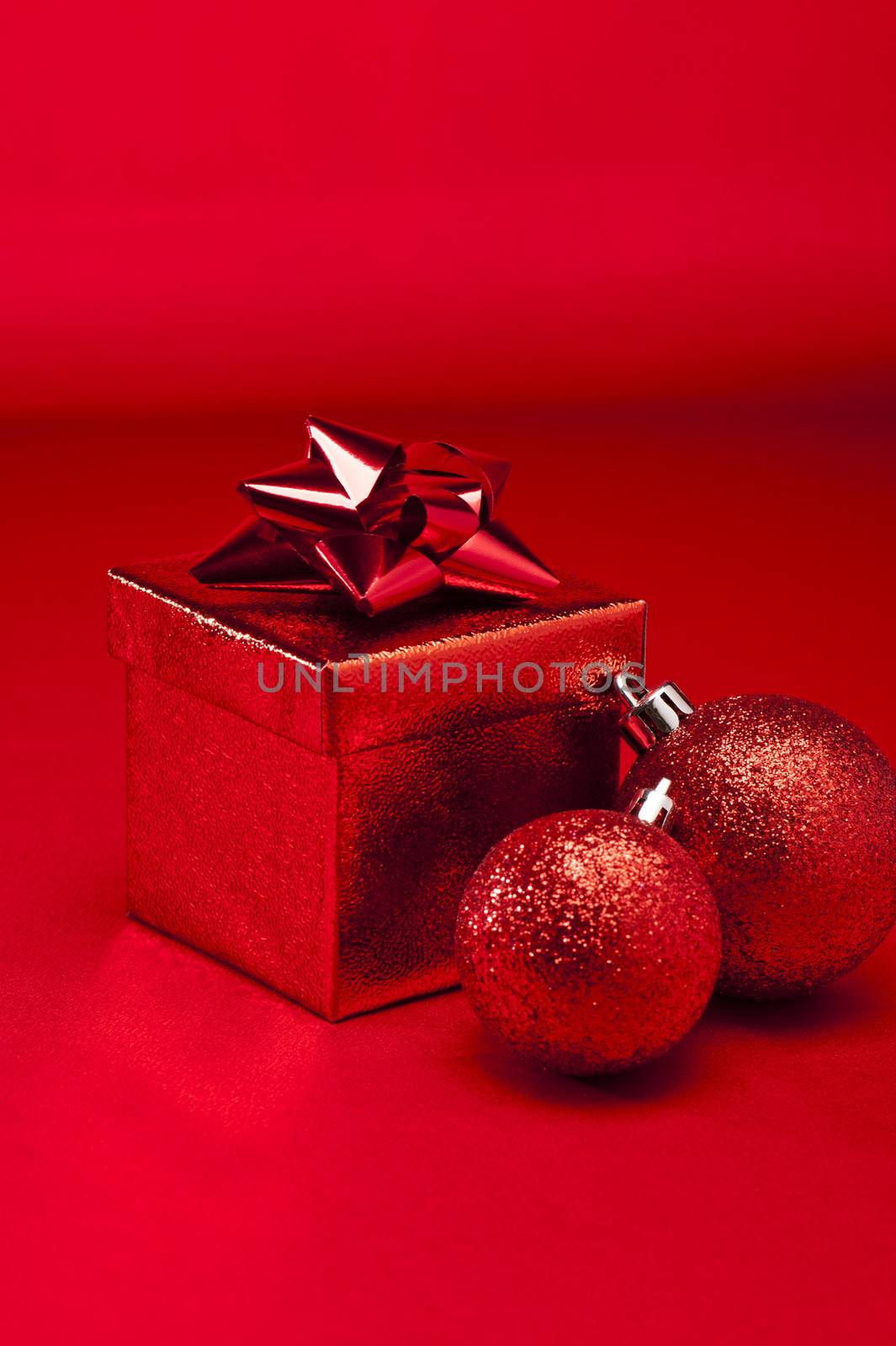Red bauble and present in red Christmas setting