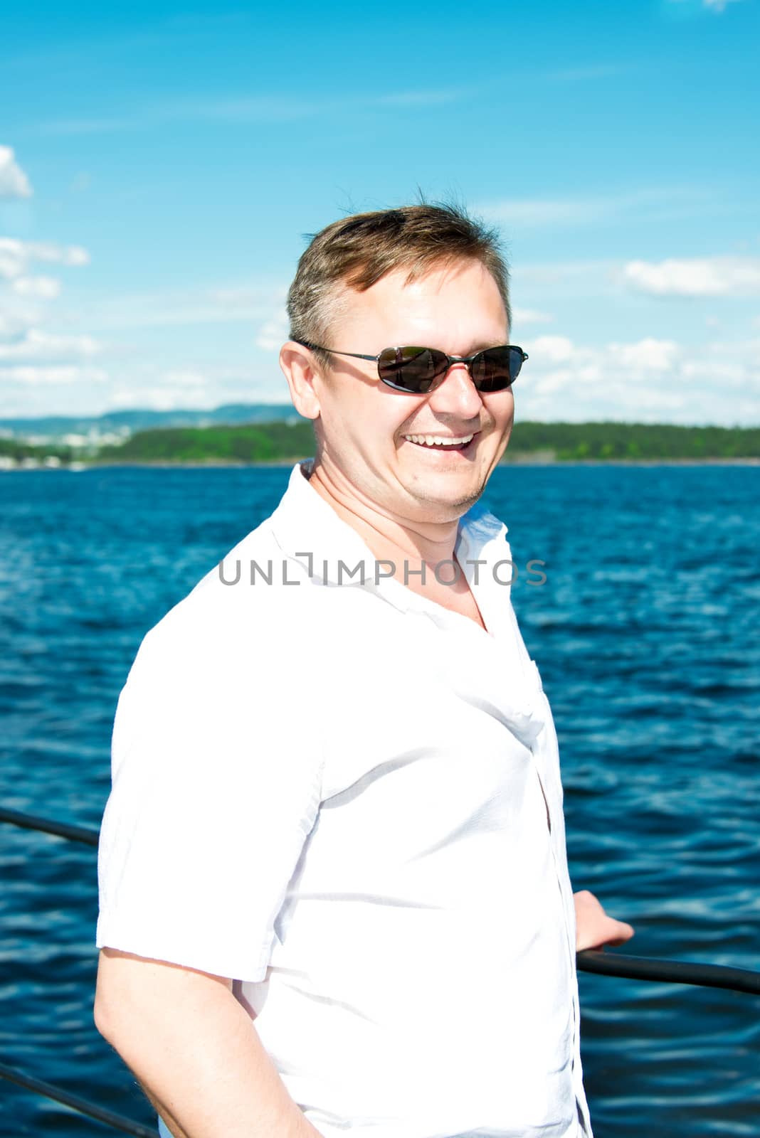 man portrait in sunglasses with sea on background by Nanisimova