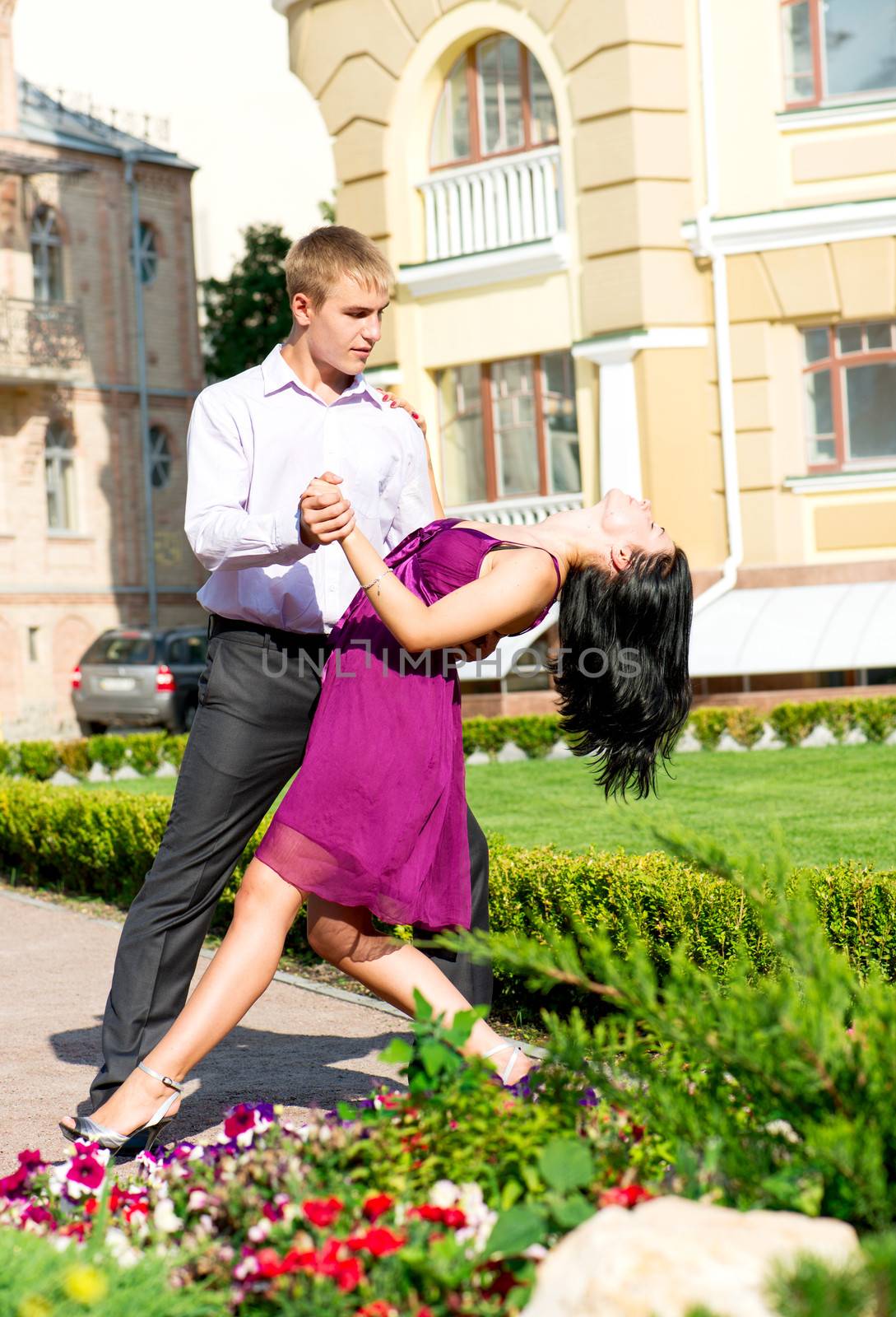Young attractive smiling couple on dancing on street