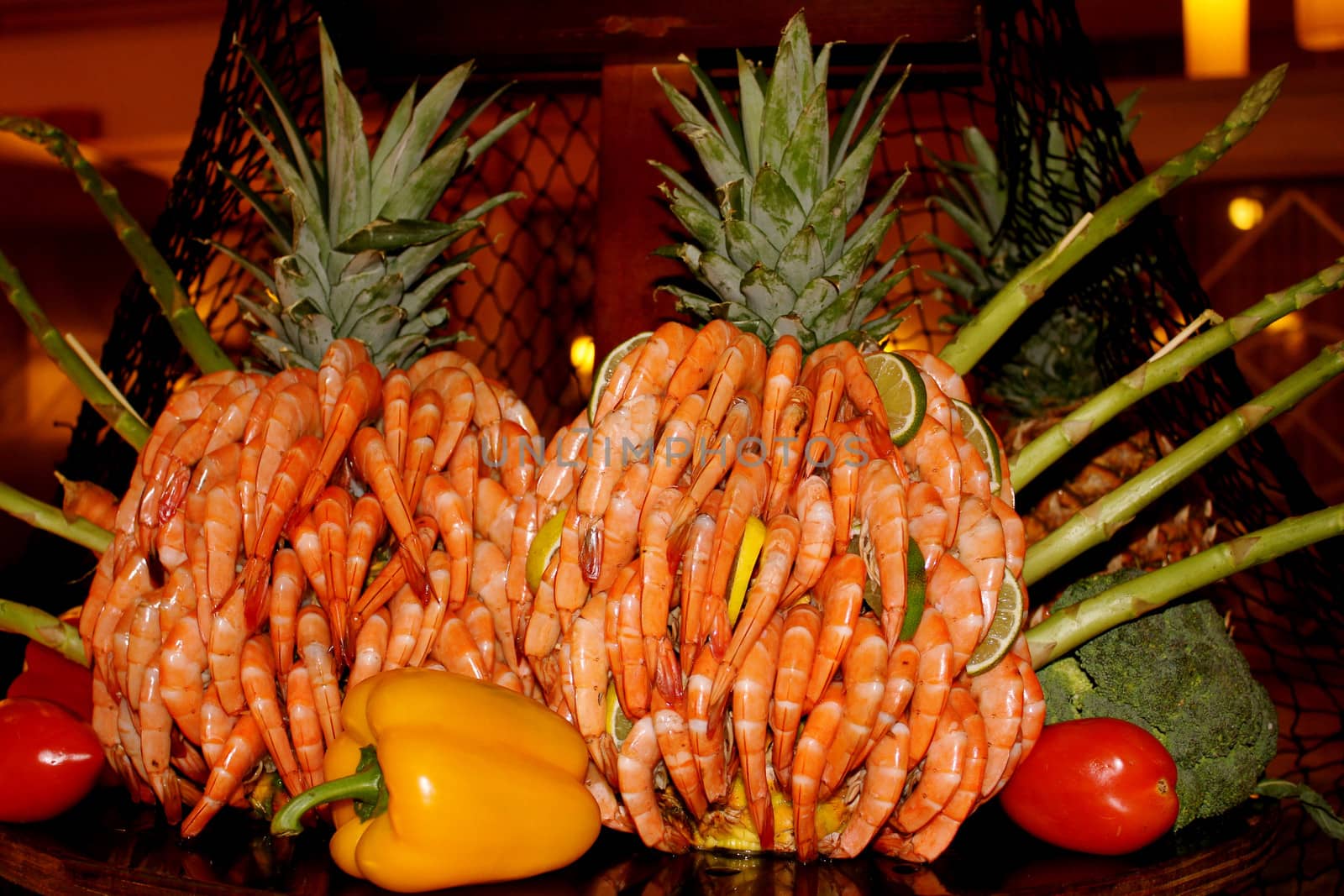 Peel and eat shrimp displayed as a pineapple sculpture on a buffet table.