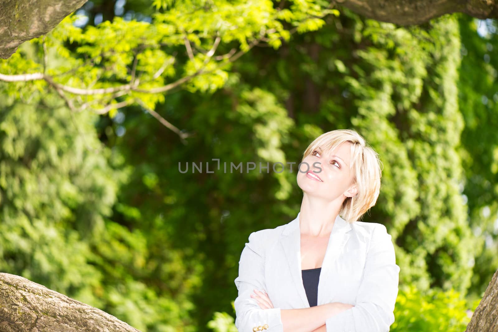 Portrait of young smiling blond woman in a park