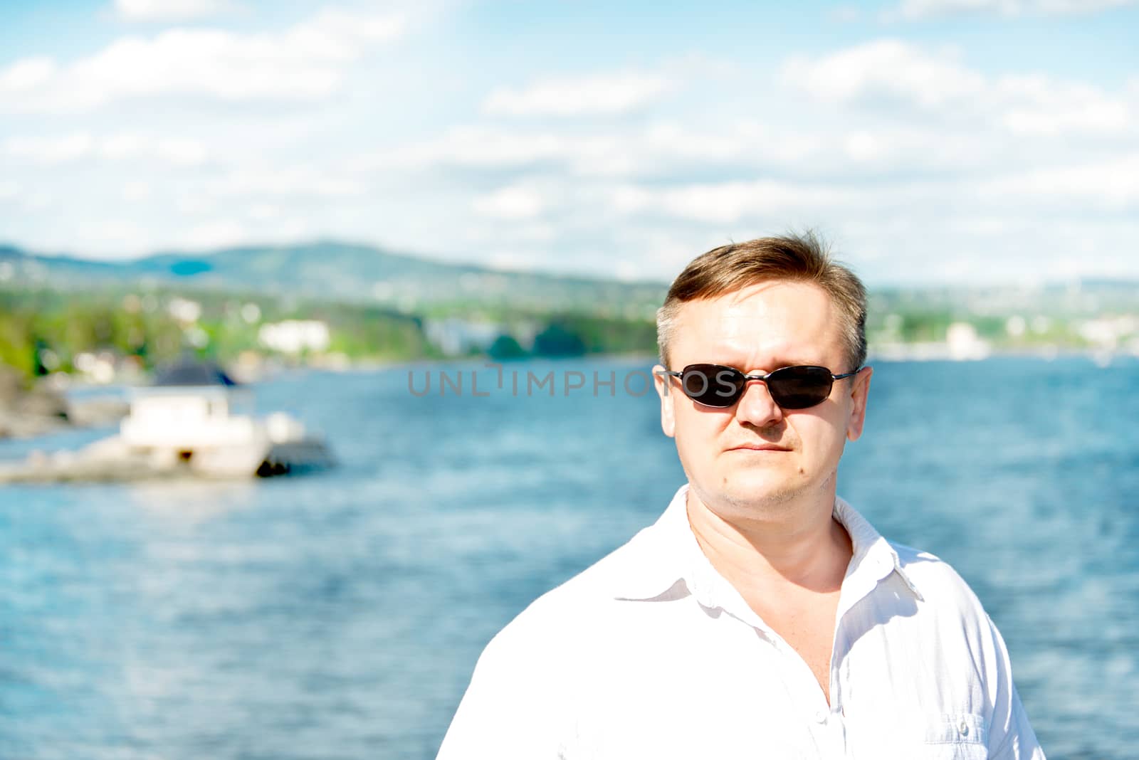 Middle aged man portrait with sea at background