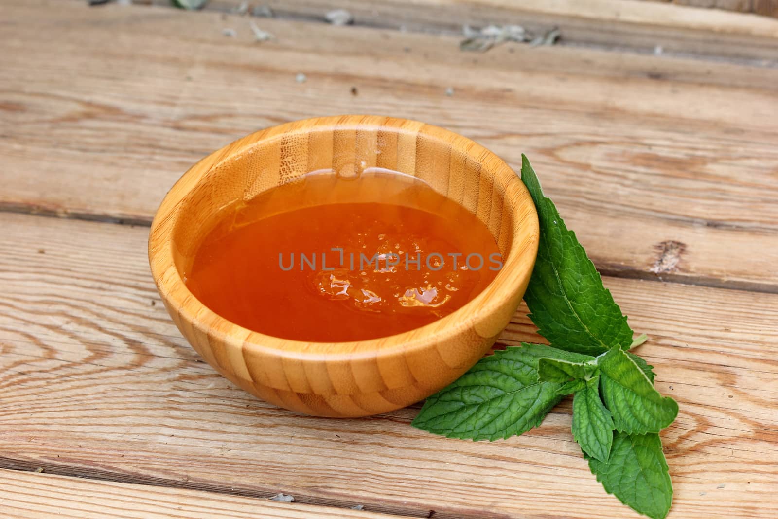 bowl with honey and mint leaves on the table