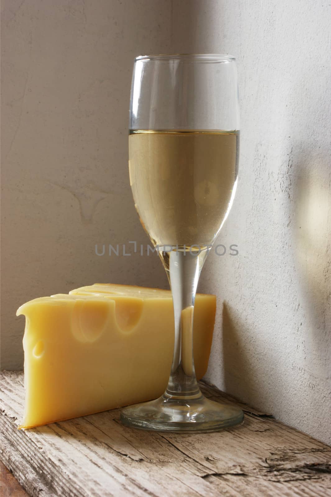 A glass of wine and cheese on the background wall