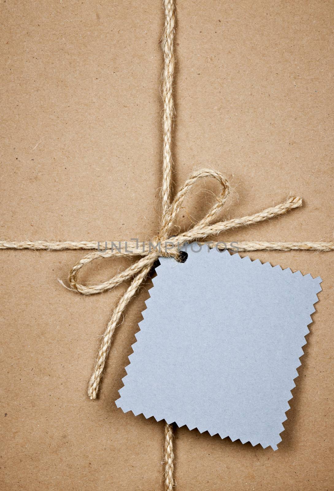 Gift with blue card in brown paper by elenathewise