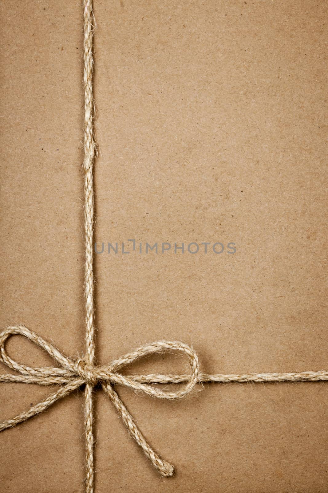 Package in brown paper tied with string by elenathewise