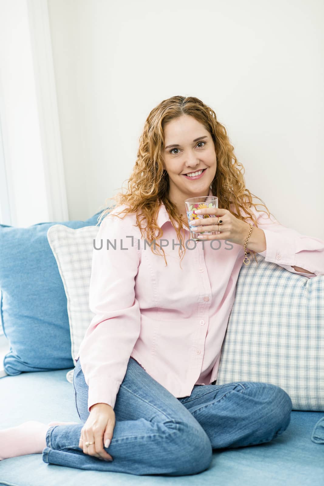 Smiling caucasian woman relaxing with glass of water