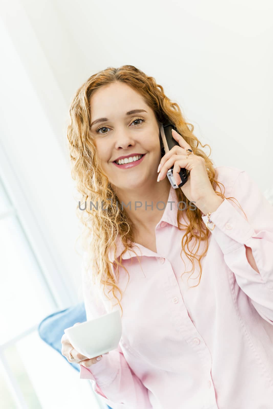 Woman talking on cordless phone by elenathewise