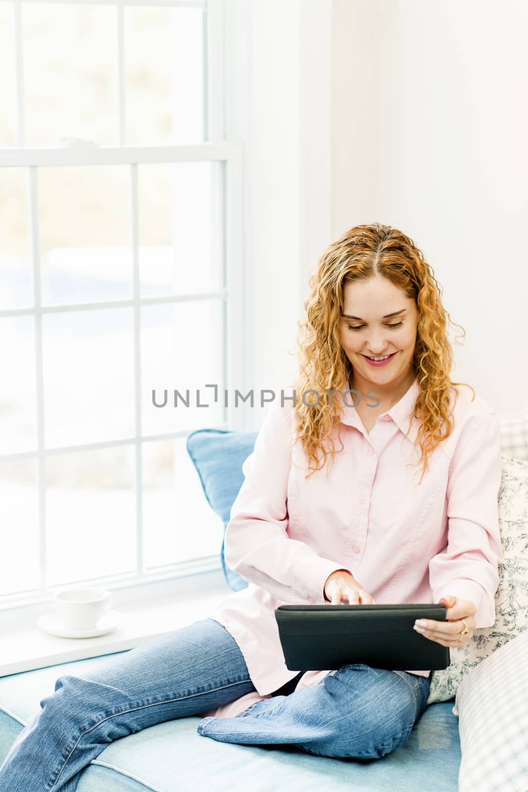 Woman with tablet computer at home by elenathewise