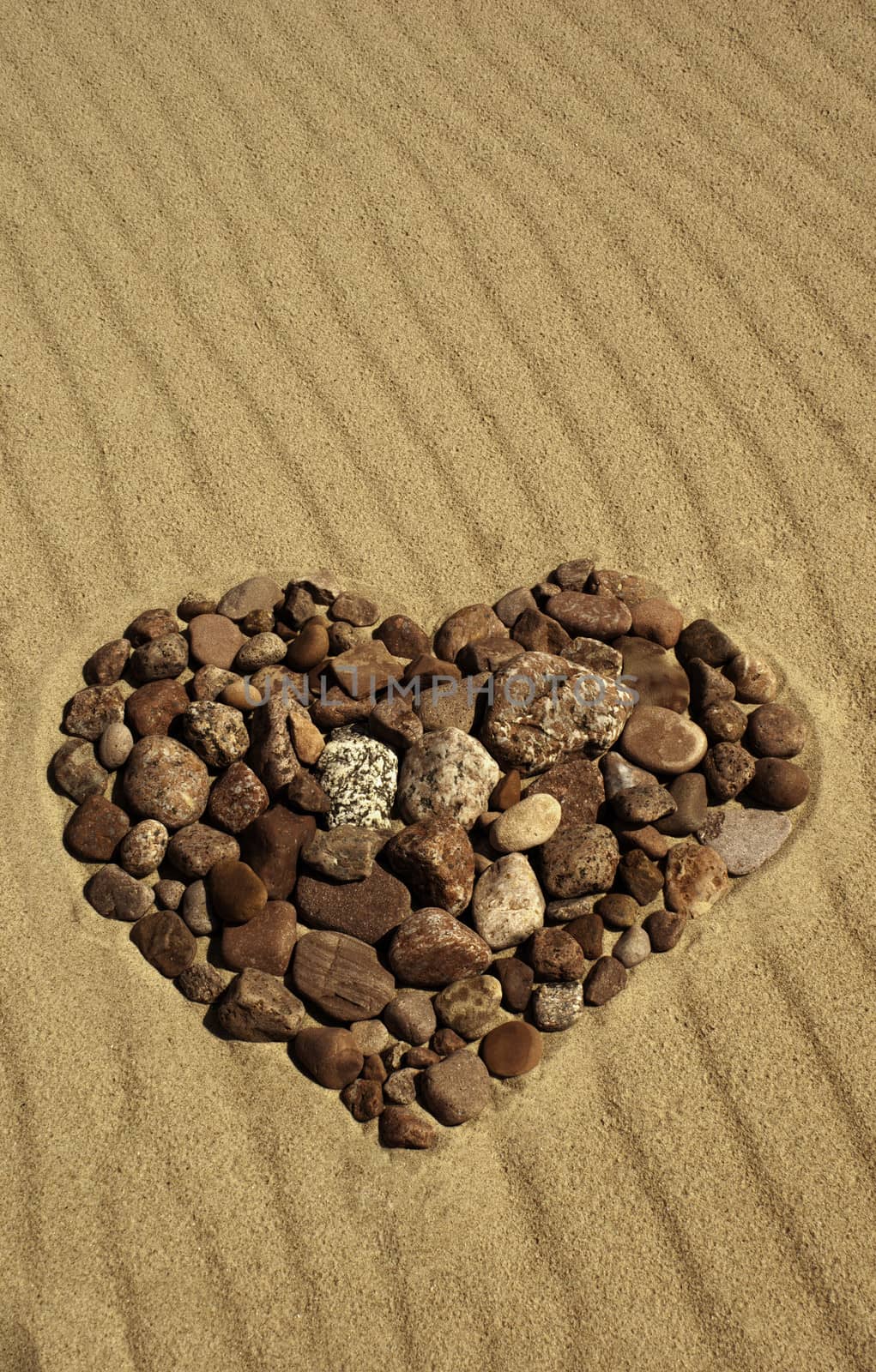 Heart made of stones in the sand