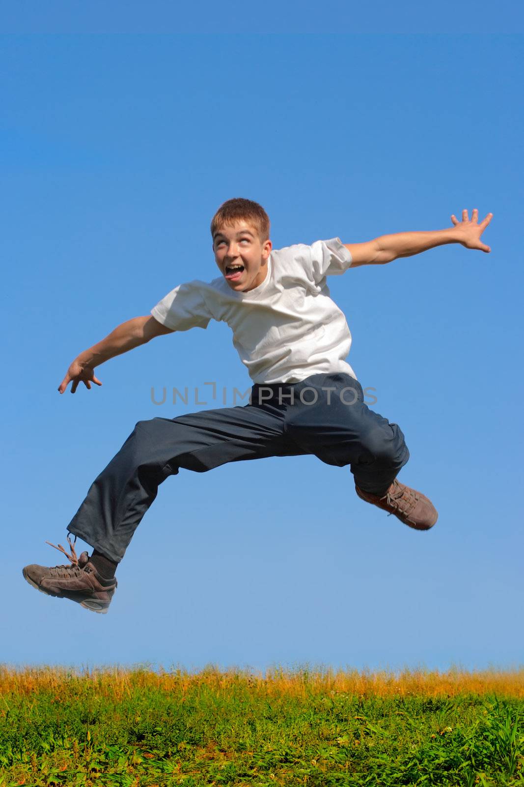 crazy young boy jumping on the blue sky background