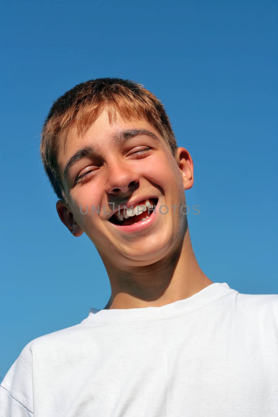 teenager laughing on the blue sky background