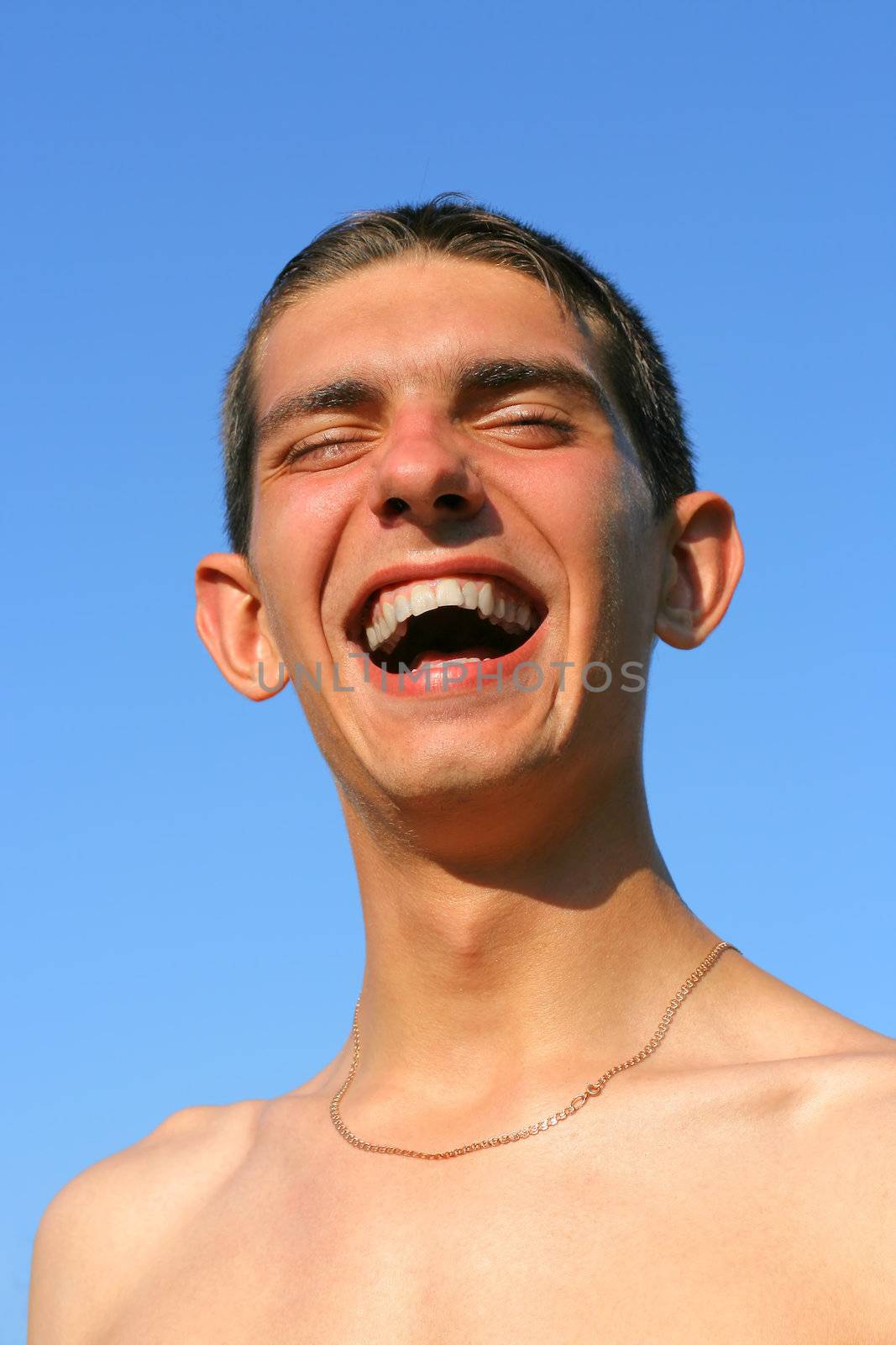 teenager laughing on the blue sky background