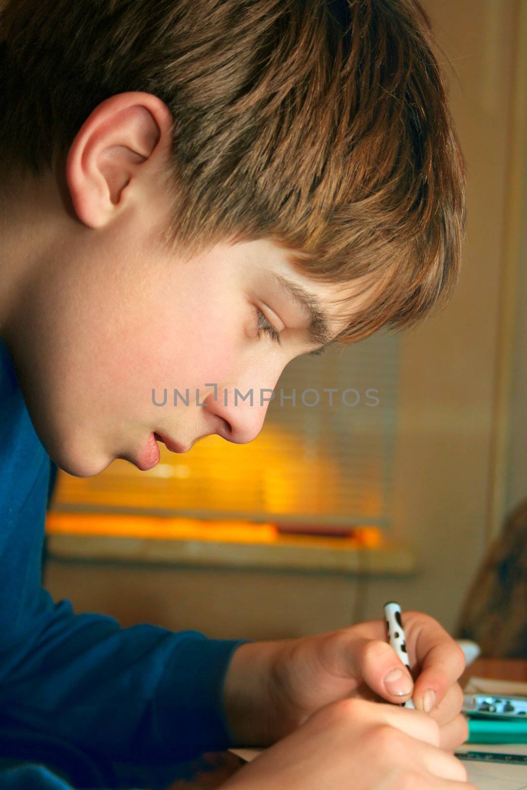 The boy doing lessons and with concentration drawing