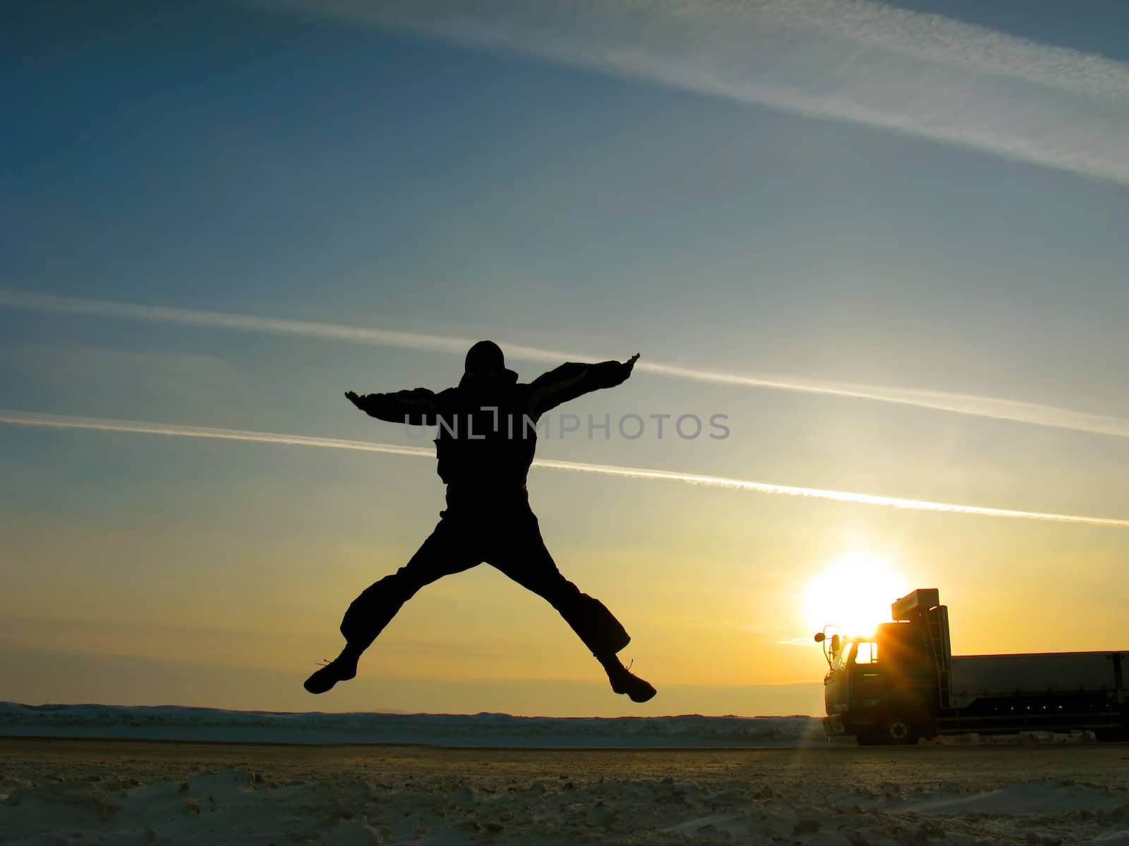 happy man jumping on the sunset sky background