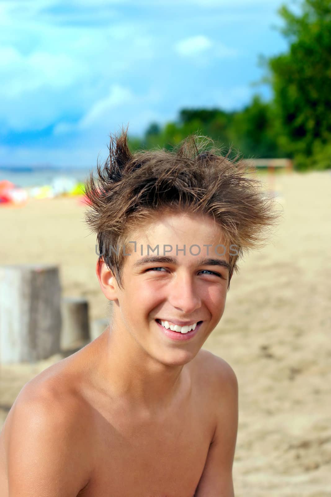 smiling happy teenager sitting on the beach