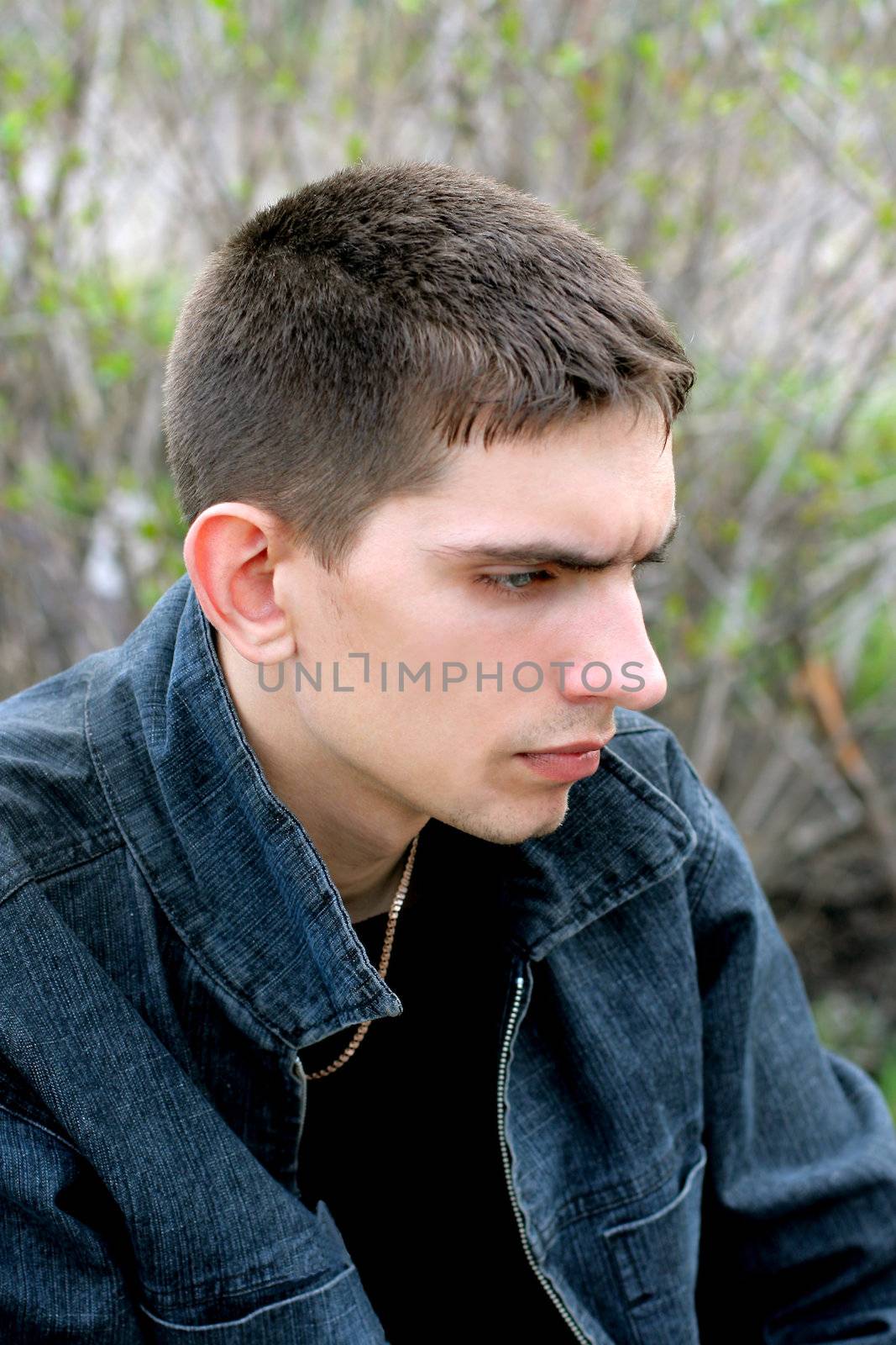 sad teenager sitting on the trees background