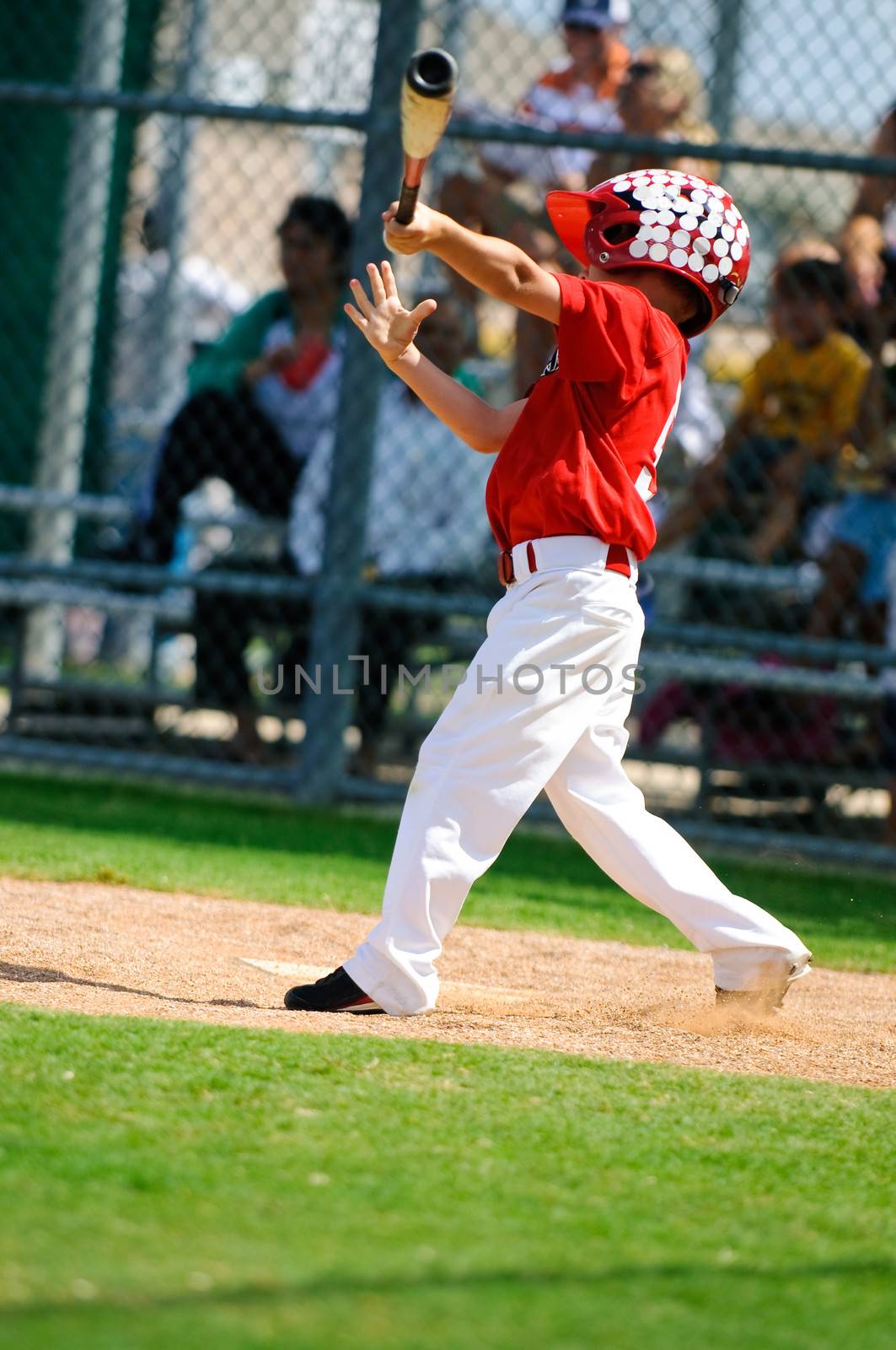Young baseball boy swinging the bat.