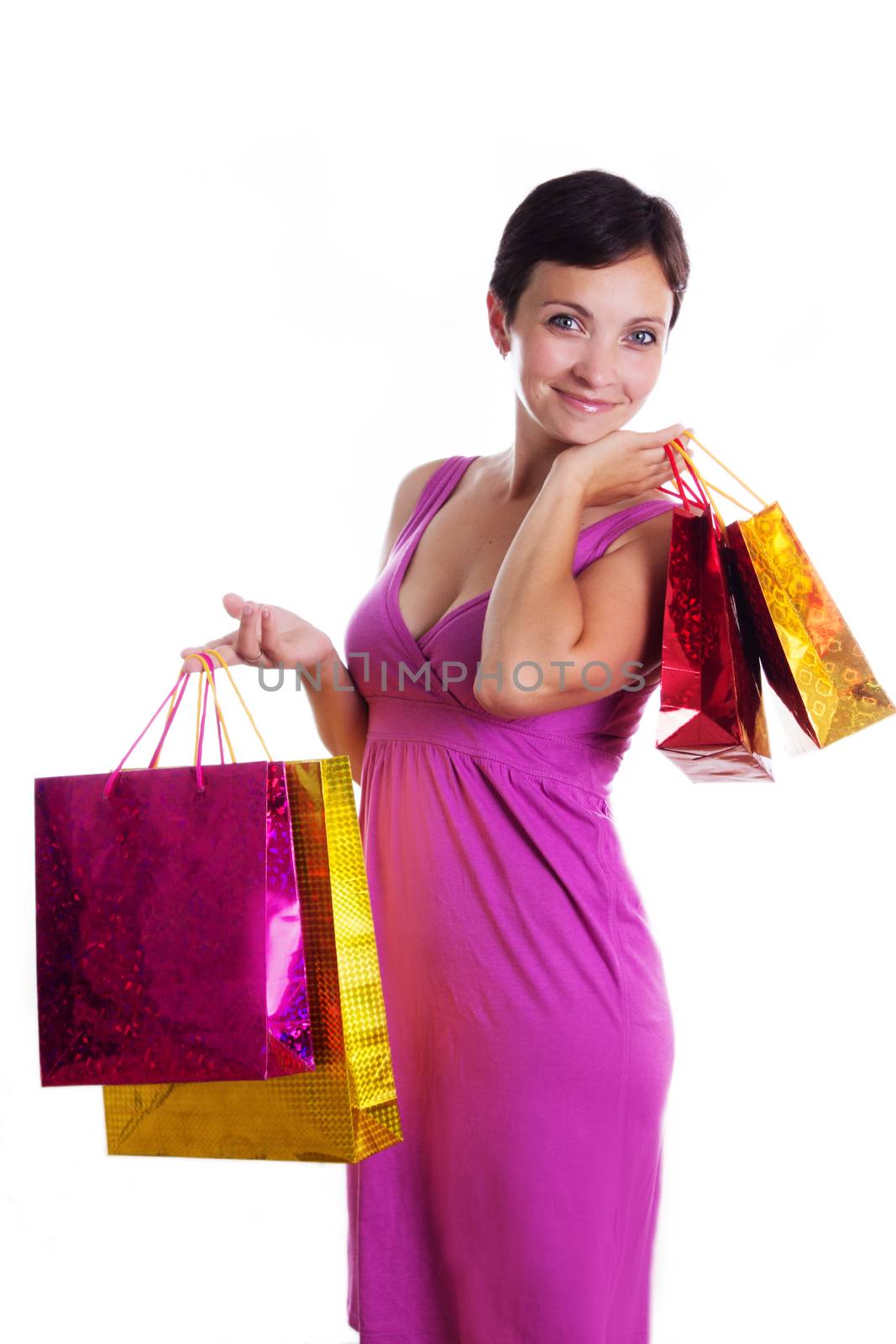 Smiling brunette in dress and with shopping bags isolated on white