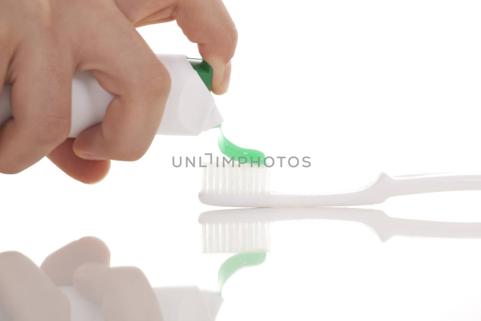 Squeezing toothpaste onto toothbrush