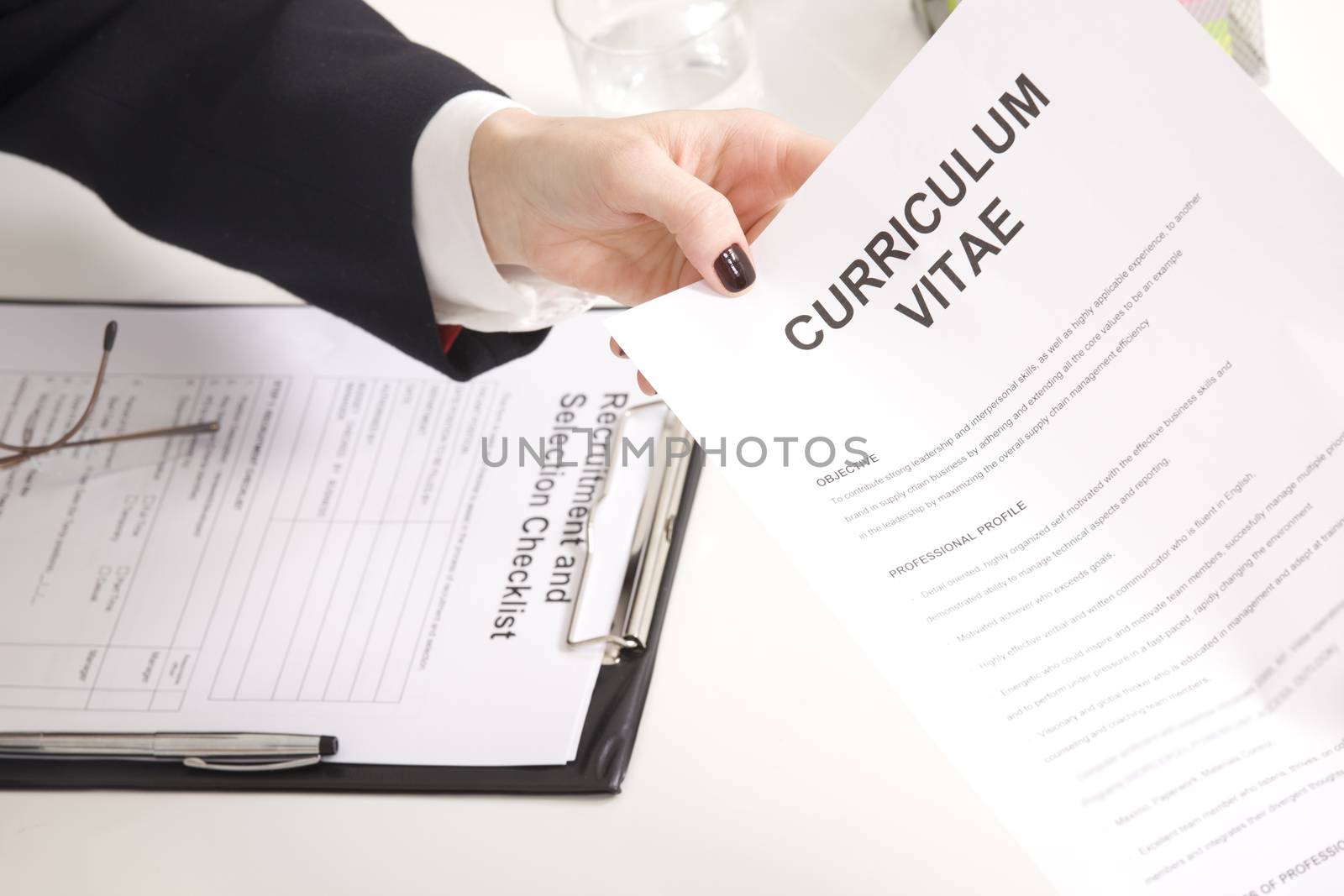 man at a a job interview with  interviewer, giving her his resume