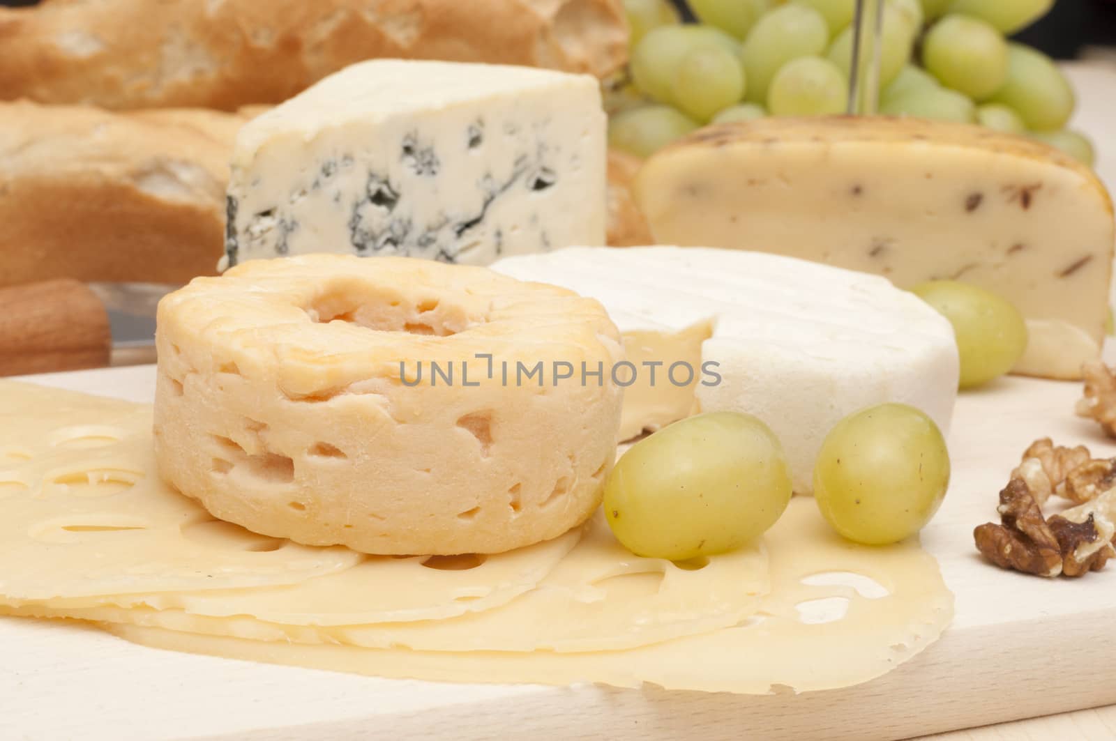 Various Types of Cheese, Grapes and Walnuts on Wooden Chopping Board 