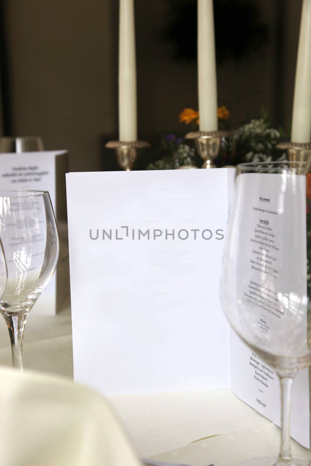 Close-up from an elegant stylish restaurant with menu, empty glasses and decorative candles