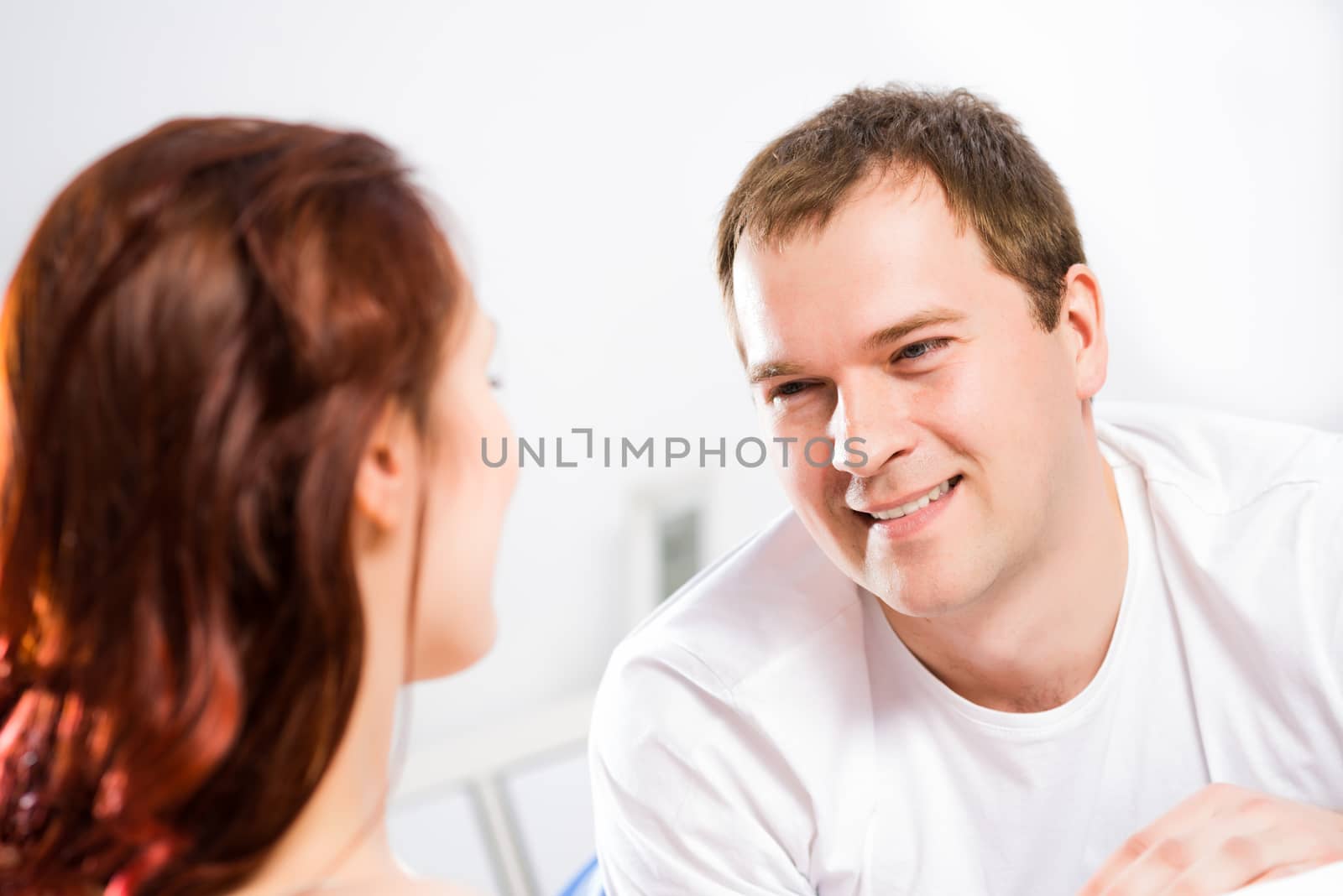 young man lying in bed with his girlfriend, spend time together at home