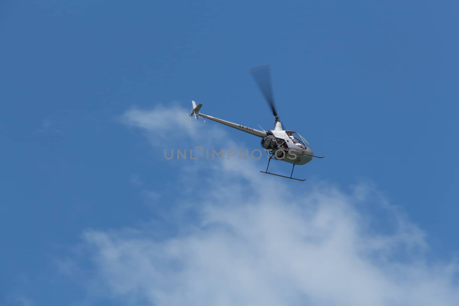 The helicopter in the clouds on a blue sky.