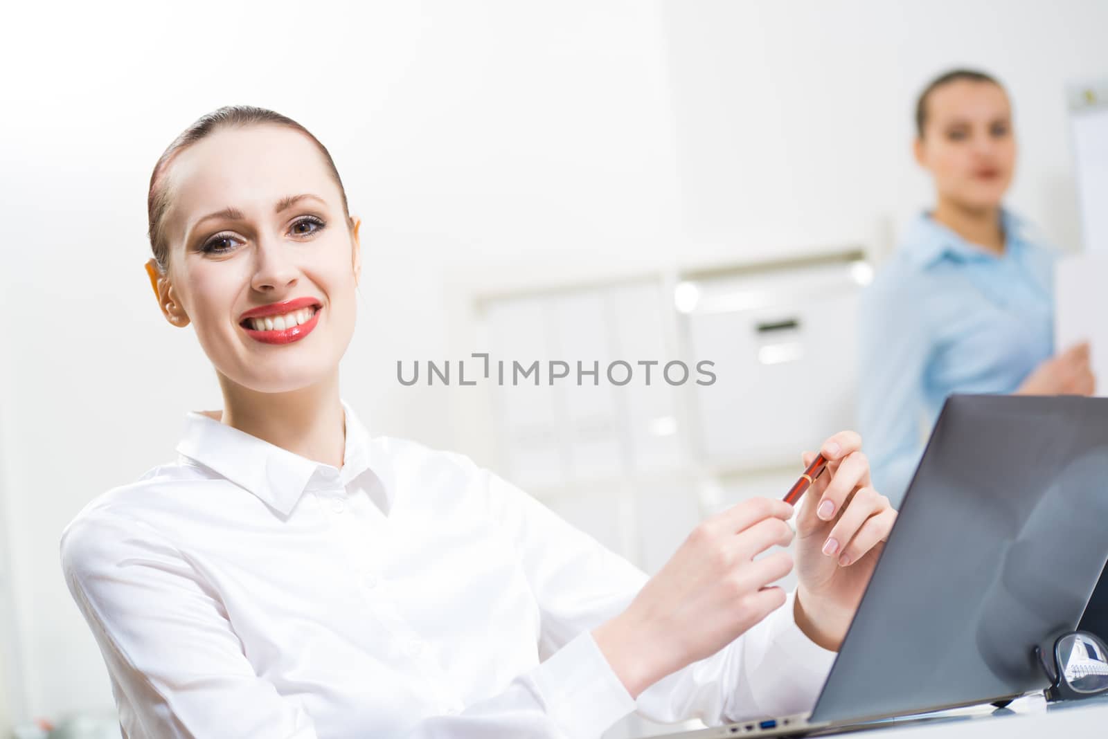 portrait of a business woman in office, smiling and looking into the camera, office work