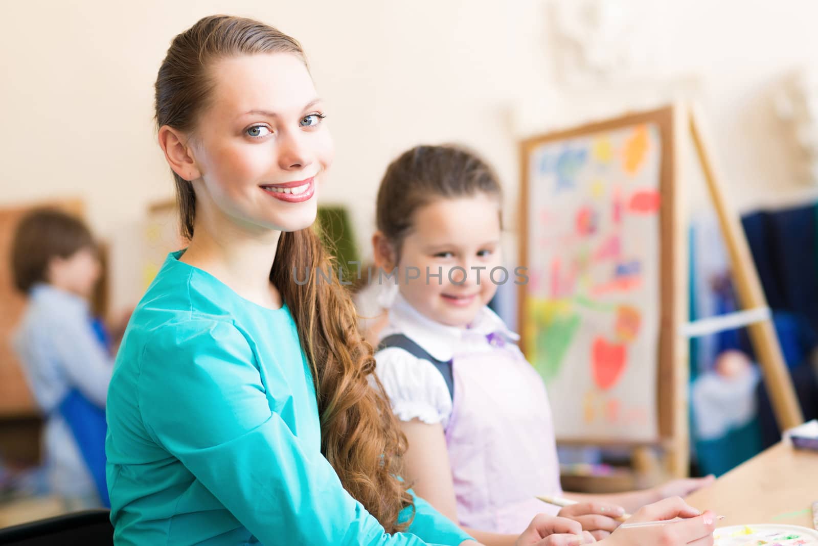 children draw with the teacher in the classroom drawing