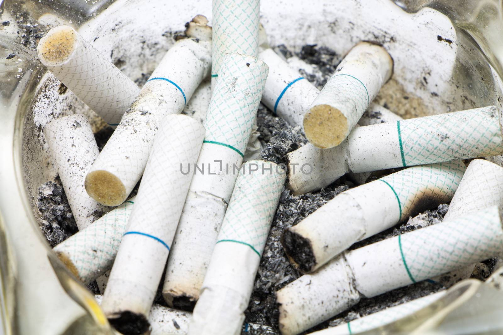 Dozen of Cigarette butt in an ashtray.