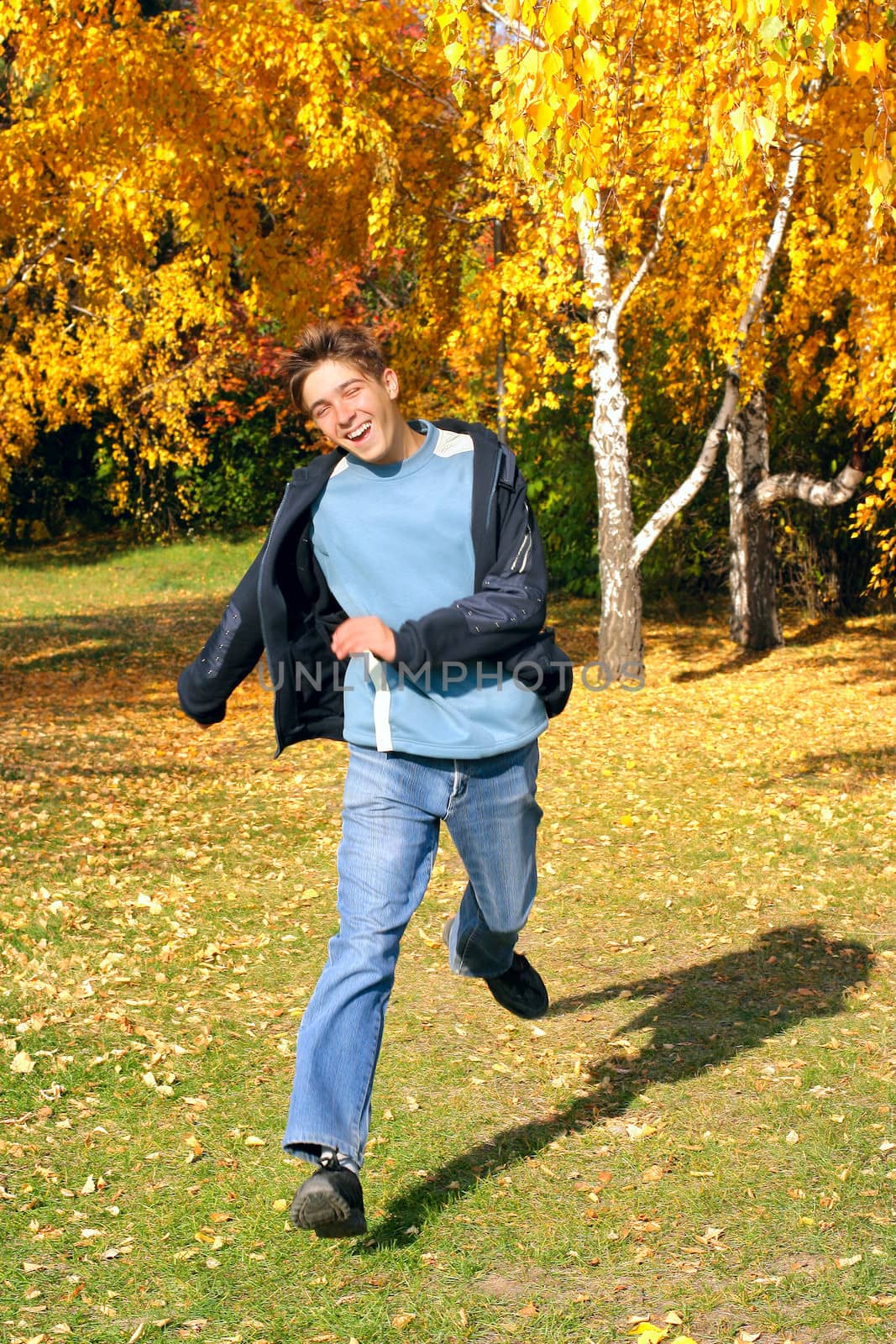 happy teenager running in the autumn park