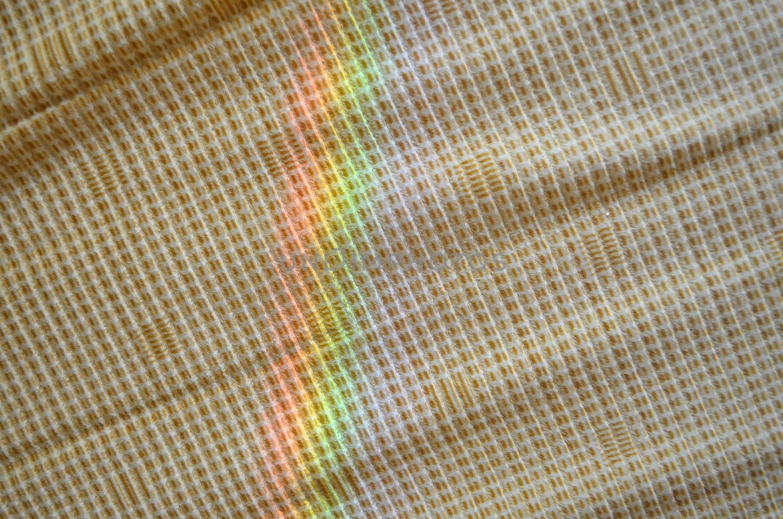 artificial rainbow light on yellow fabric background.