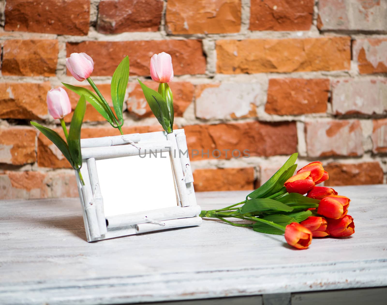 photo frame with bouquet of tulips on a white table