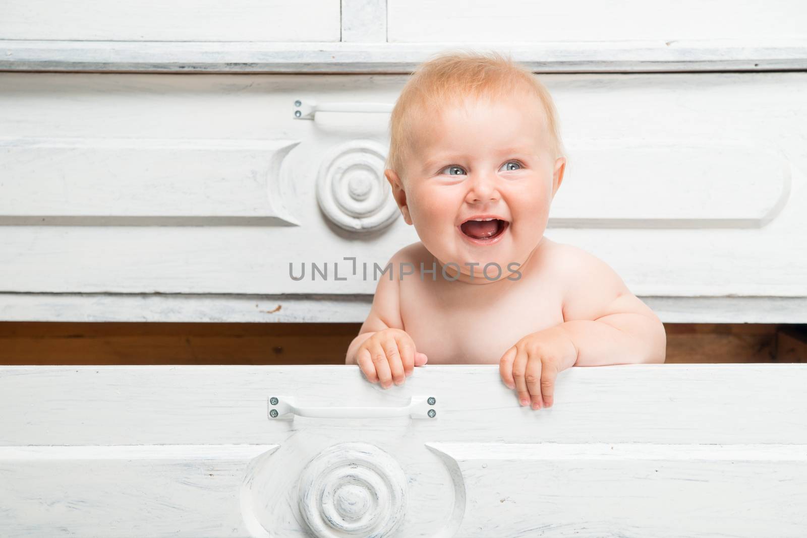 Cute smiling little baby in a drawer
