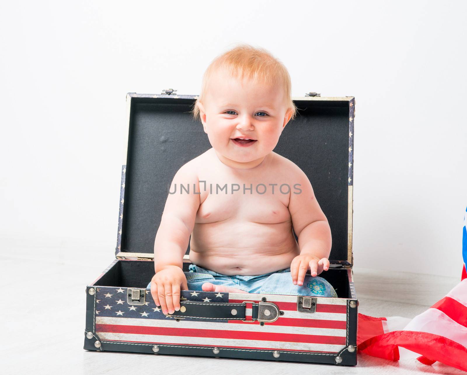 smiling baby in a suitcase with American flag