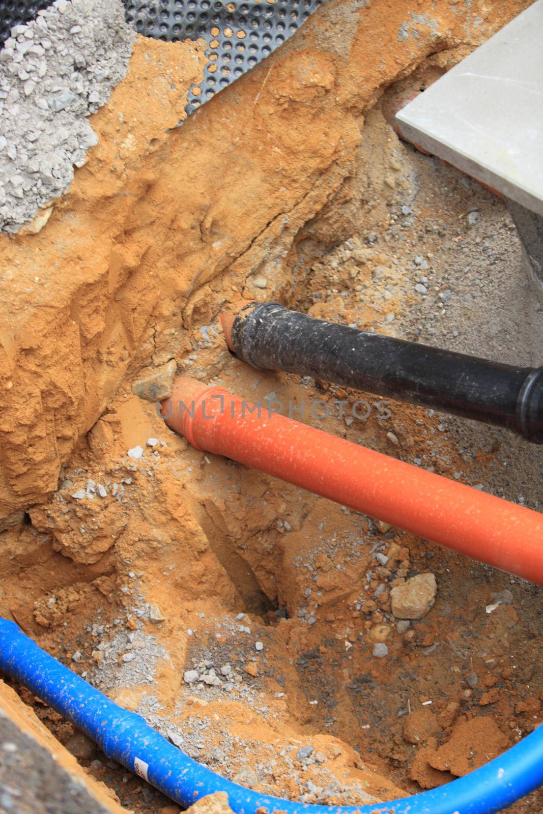 Incoming utilities to a domestic house passing underground through plastic conduit piping
