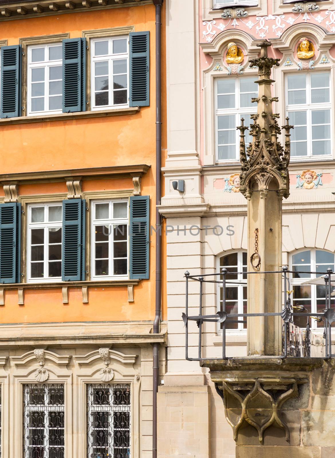 Old pillory post above fountain at Schwabisch Hall, Germany. Dating from 1509, the fountain stands against a decorative wall adorned with statues of Samson, St Michael and St George. The rectangular design is unusual in a Gothic fountain.