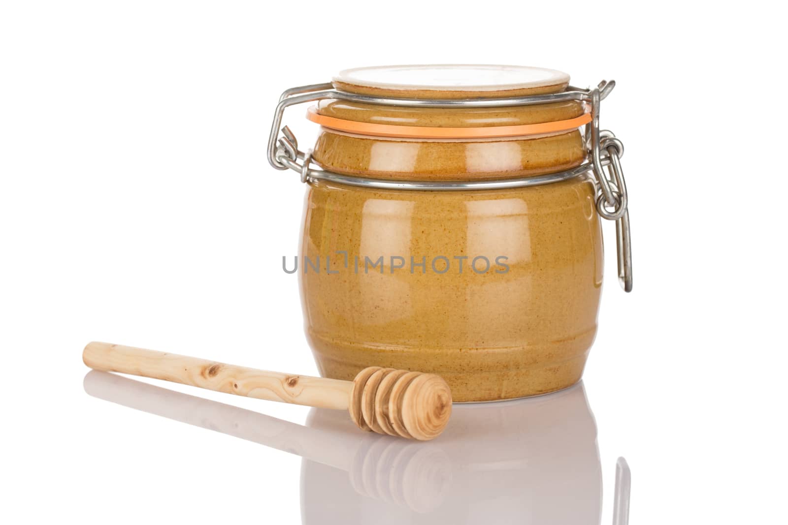 Honey pot and stick isolated on white background close up.