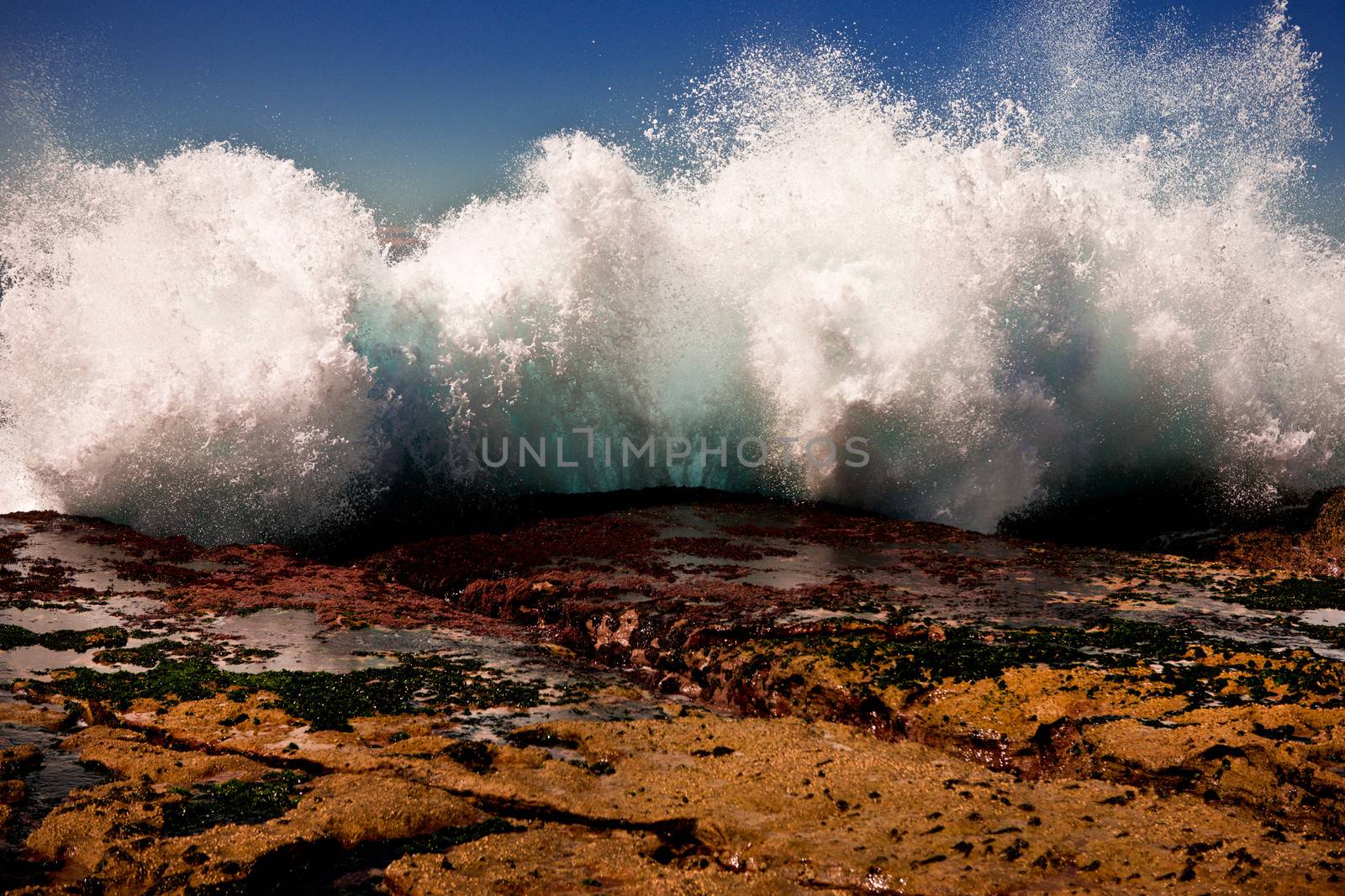 Powerful spray from a crashing wave by jrstock