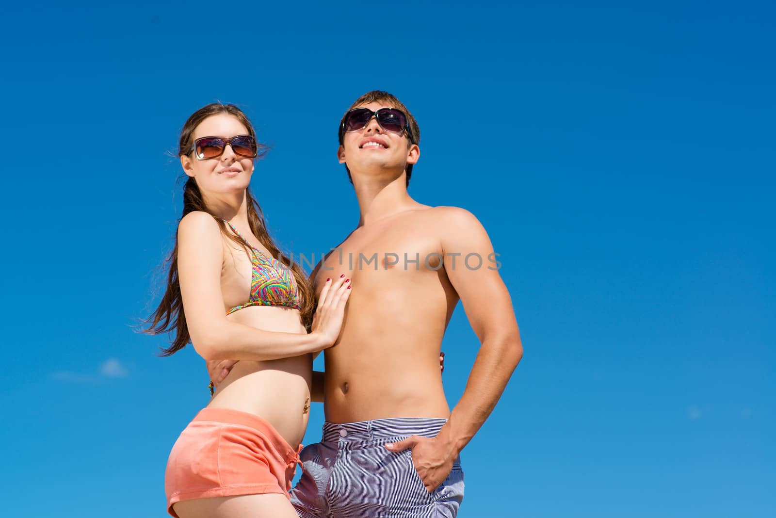 Young couple hugging on a background of blue sky, hold together honeymoon