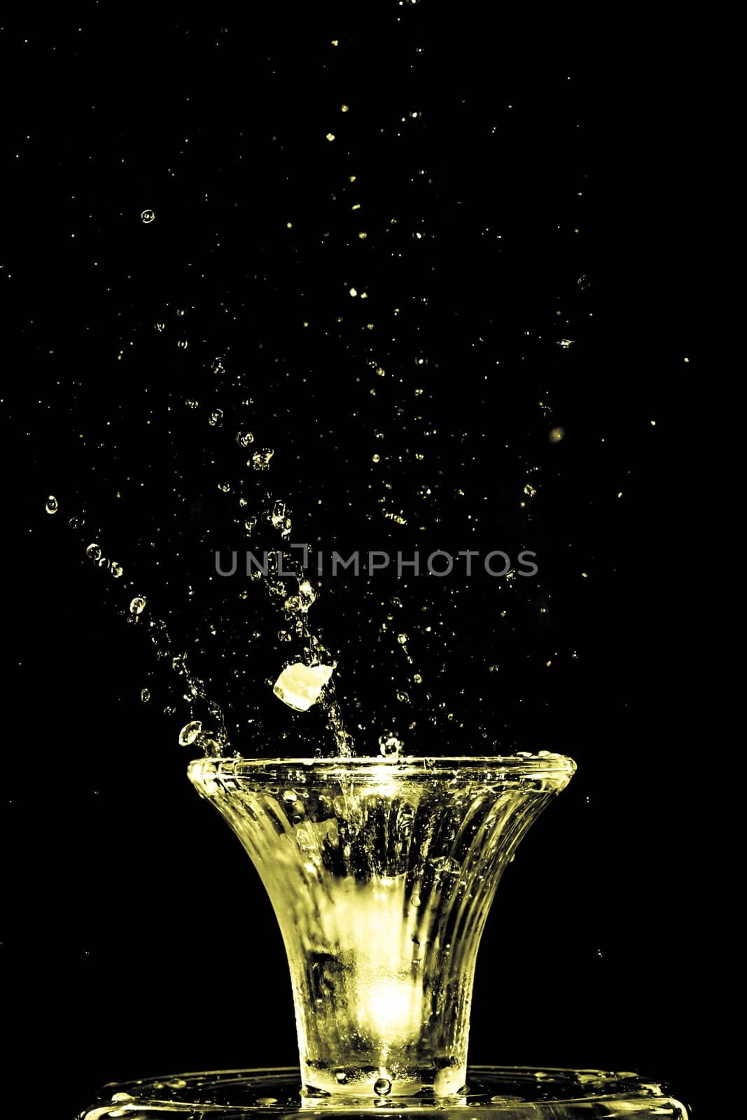 Stroboscopic effect created using flash capturing the motion ice as it splashes into a glass